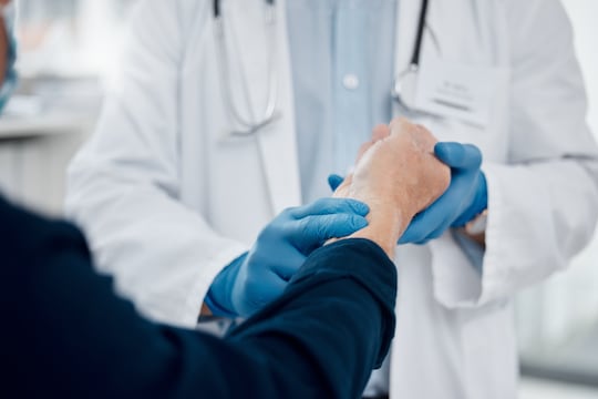 Doctor, hands and consulting at hospital for pulse on wrist, wellness centre or healthcare clinic checkup. Nurse, person and medical examination and medicine employee in heart rate help for patient