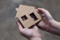 homeless boy holding a cardboard house