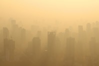 Buildings under construction with cranes in misty morning, Bangkok, Thailand