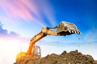 Excavator working at construction site on sunset