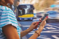 Woman using cellphone and crossing the street.