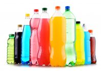 Plastic bottles of assorted carbonated soft drinks over white background