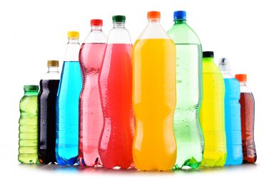 Plastic bottles of assorted carbonated soft drinks over white background