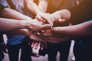 Arms together, teamwork. Collaboration