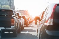 Evening traffic jam on busy city highway. Rows of car stck on road due to crush accident. Sunset metropolis rush hour scene.