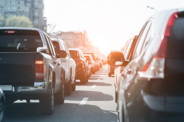 Evening traffic jam on busy city highway. Rows of car stck on road due to crush accident. Sunset metropolis rush hour scene.