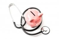Healthcare cost and the high price of quality health care insurance concept theme with a stethoscope and a pink piggy bank isolated on white background