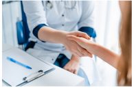 Close up of female medicine doctor shaking hands with patient