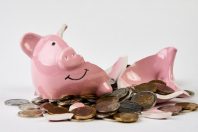 Broken piggy bank with coins money isolated on white background, close-up