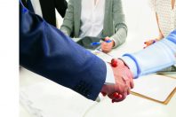 Business meeting at the table shaking hands conclusion of the contract