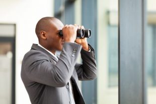 african american businessman using binoculars