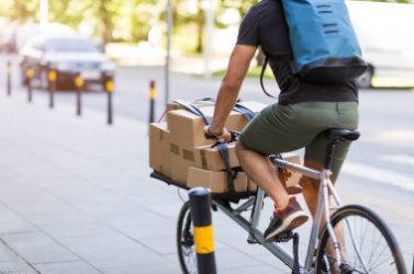 Bicycle messenger making a delivery on a cargo bike