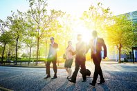 Colleagues walk and talk in the city sun