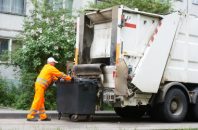 Worker of urban municipal recycling garbage collector truck loading waste and trash bin