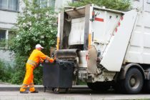 Worker of urban municipal recycling garbage collector truck loading waste and trash bin