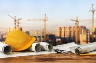 Concept of construction and design. 3d render of blueprints and designer tools on the panorama of construction site.