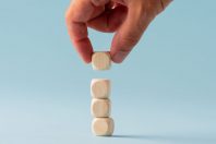 Stacking four blank wooden dices