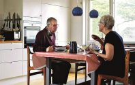 Full length of senior couple eating food at dining table