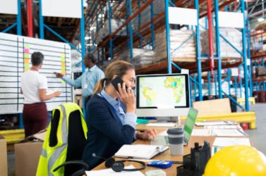 Female manager talking on mobile phone at desk