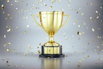 First place gold trophy cup with falling golden confetti. Award ceremony concept. 3d rendering