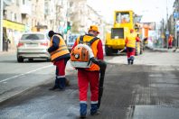 Worker with leaf-blower, cleaning out the dust for better asphal