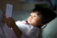Une jeune enfant regarde un smartphone