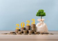 gold wooden number 2023 on a stack of coins for investment, and