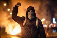 A hooded protester during a night of rioting in Paris - generative ai