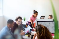 Computer programmers and designers working in open plan office