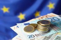 Coins and banknotes against European Union flag, closeup. Space