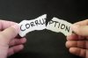 Stop and fight corruption concept. Human hand tearing a piece paper with written word corruption.