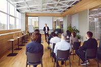 Business coach giving a lecture to a group of people in a classroom or office conference room