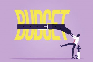 Tight budget and recession shrinking economy concept, Saving money, Businessman use belts tighten budget word, economy concept
