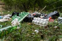 Pollution in nature - garbage thrown on the field covering grass