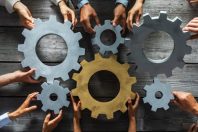 Business people joining gears