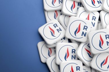 Elections in France. Logo of the far right party "Rassemblement National" on a heap on a table. Web banner format with copy space.