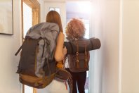Young women with backpacks arriving to a youth hostel
