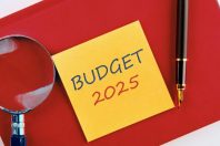 Business concept. The inscription BUDGET 2025 on a yellow sticker on a red business notebook in a composition with a magnifying glass and a fountain pen