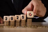 2025 new year budget planning concept. Businessman hand is holding a wooden block with a target drawn on it and 2025 wooden text block on coin stack for setup objective target business cost.