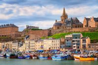 Gothic church on the hill and fishermen boats in port town Granv