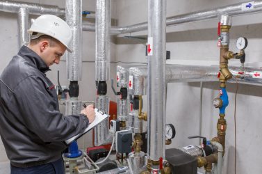 Technician inspecting heating system in boiler room