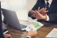Businessman rejecting money, Euro banknotes, from his partner while making contract