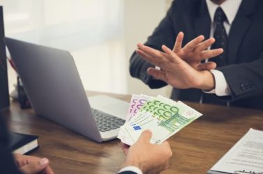 Businessman rejecting money, Euro banknotes, from his partner while making contract