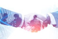 Handshake in city. Double exposure of planet hologram. International business partnership concept and hi tech. Toned image