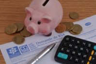 Vannes, France, 18 juin 2023 : Formulaire de demande de revenu de solidarité active avec une tirelire et des pièces de monnaie en euro