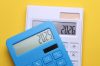 Calculators with 2025 and 2026 on a yellow background. Economic analysis of the year