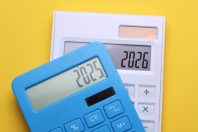 Calculators with 2025 and 2026 on a yellow background. Economic analysis of the year