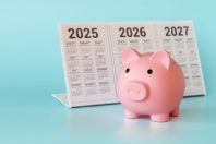 A piggy bank in the form of a pink piglet and a desktop calendar for 2025-2027 on a light blue background. The concept of long-term investments.