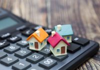 Buy home. House is placed on the calculator. Planning savings money of coins to buy a home concept for property, mortgage and real estate investment.