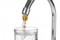 Euro coins flowing with water from a tap on white background